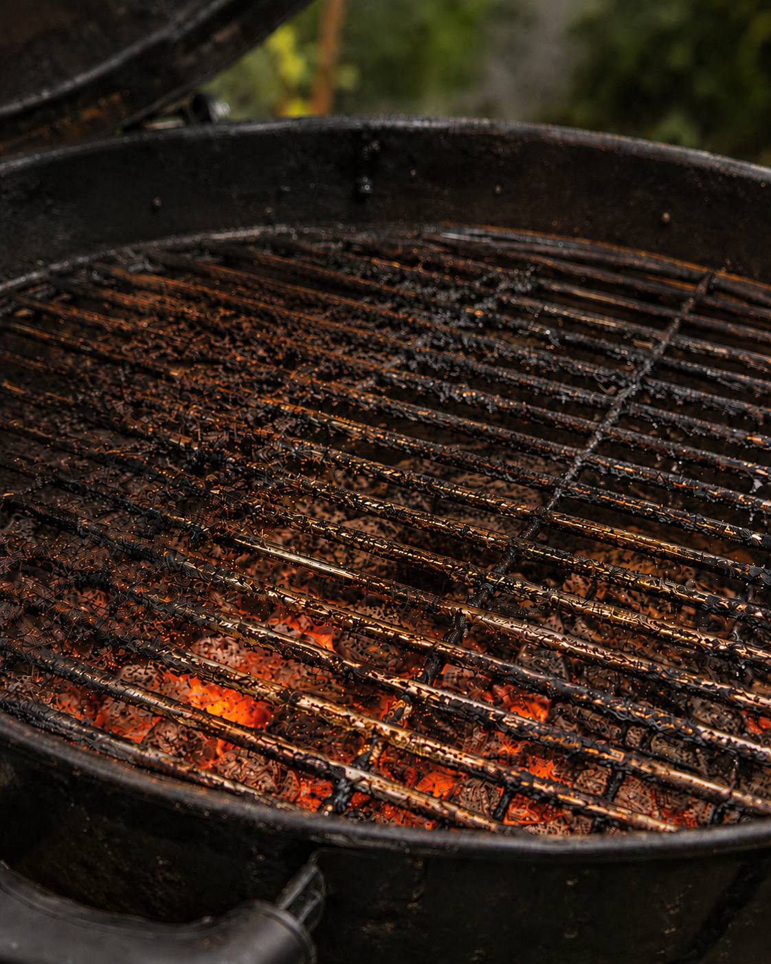 Grillin puhdistus käynnissä – pinttynyt grilliritilä hehkuvien hiilien päällä
